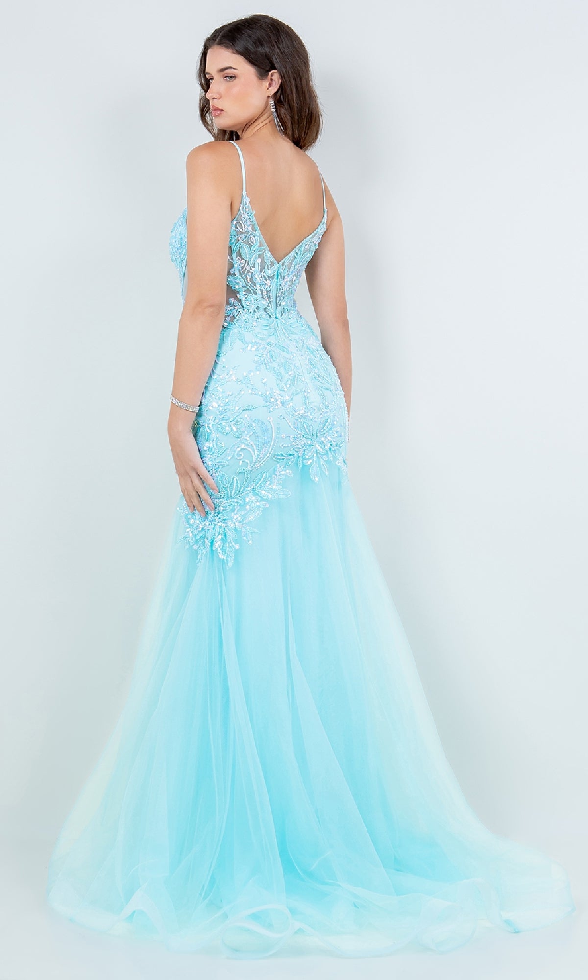 A woman shown from the back wearing the Cinderella Couture 8276J, a light blue long mermaid prom dress with lace detailing and a sheer tulle skirt.